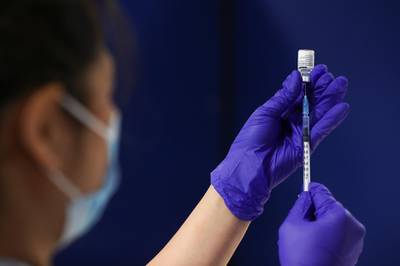 A healthcare worker fills a syringe with a dose of the Pfizer-BioNTech coronavirus disease (COVID-19) vaccine at the Newcastle Racecourse vaccination centre, in Newcastle upon Tyne, Britain. Reuters