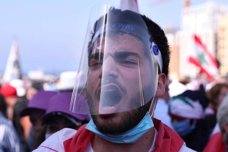A Lebanese protester wears a visor as protection against the coronavirus.  AP