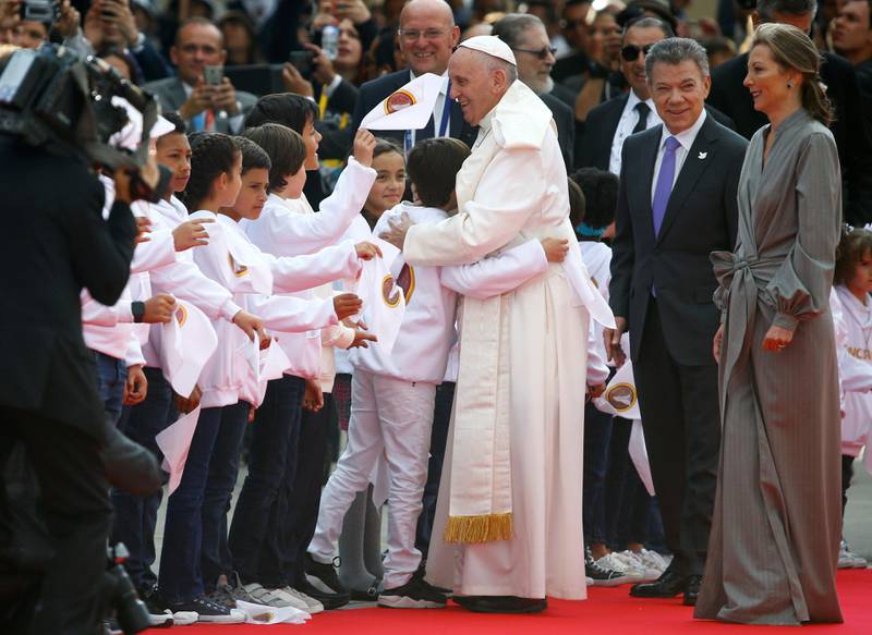 Pope Francis greets children next to Colombia's President Juan Manuel Santos (2nd R) and his wife Maria Clemencia Rodriguez  upon his arrival in Bogota, Colombia, September 6, 2017. REUTERS /  Stefano Rellandini - RC1838DCF050