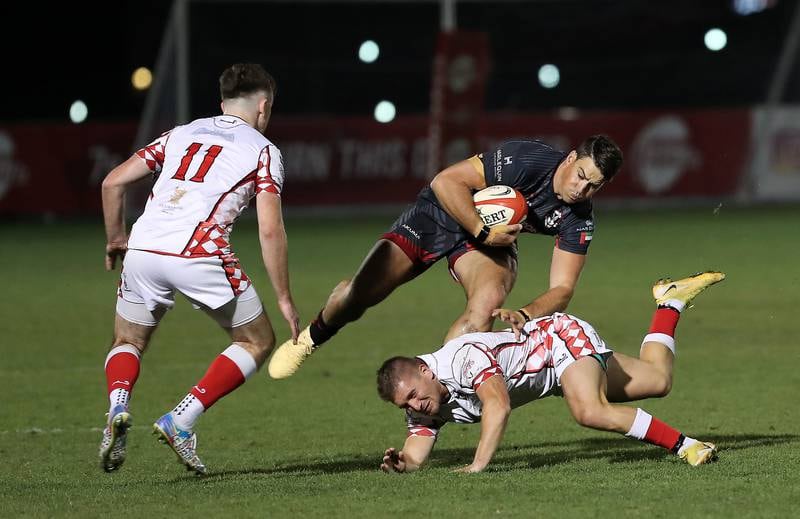 A Dubai Exiles player attempts to avoid a tackle from Abu Dhabi Harlequins.