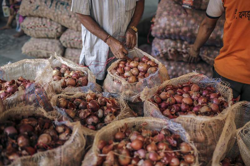 A worker seals a sack of onions at the Vashi Agricultural Produce Market Committee (APMC) wholesale market in Mumbai, India, on Thursday, Oct. 3 2019. Onions in India are once more at the epicenter of a major controversy, pitting government officials who want lower prices against farmers that need extra income. Photographer: Dhiraj Singh/Bloomberg
