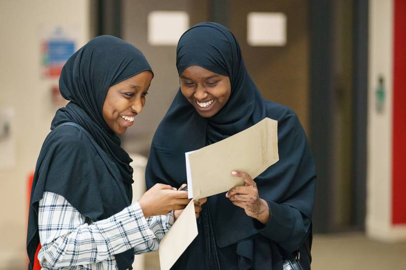 Yasmin Adan, left, and Asmaa Ali receive their A-level results at Oasis Academy Hadley in Enfield, north London. PA