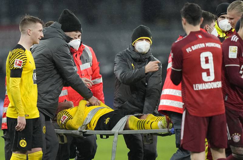 Dortmund's Julian Brandt, centre, leaves the field on a stretcher after a collision with Bayern's Dayot Upamecano. AP Photo