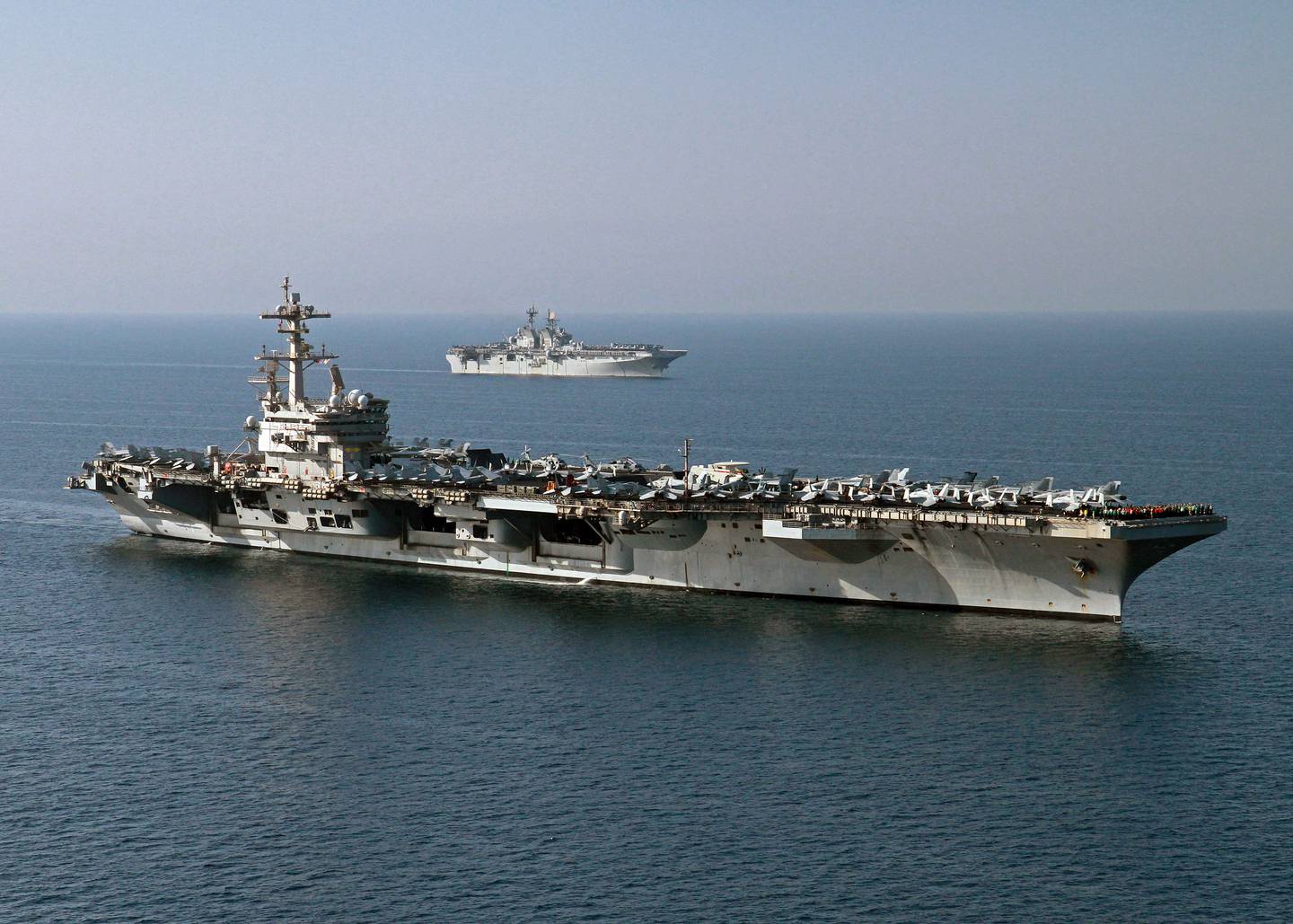 This US Navy photo obtained October 14, 2014 shows the amphibious assault ship USS Makin Island (LHD 8)as it pulls alongside the aircraft carrier USS George H.W. Bush (CVN 77) for a vertical replenishment on October 10, 2014 in the Gulf. George H.W. Bush is supporting maritime security operations, strike operations in Iraq and Syria as directed, and theater security cooperation efforts in the US 5th Fleet area of responsibility. AFP PHOTO/US NAVY/ Juan D. Guerra = RESTRICTED TO EDITORIAL USE - MANDATORY CREDIT "AFP PHOTO / US NAVY/ Juan D. Guerra /HANDOUT" - NO MARKETING NO ADVERTISING CAMPAIGNS - DISTRIBUTED AS A SERVICE TO CLIENTS = (Photo by Juan David Guerra / US NAVY / AFP)