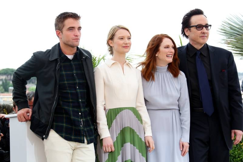 Robert Pattinson goes casual in a leather jacket, checked shirt and chinos, next to Mia Wasikowska, Julianne Moore and John Cusack at the 'Maps To The Stars' photocall during the 67th Annual Cannes Film Festival on May 19, 2014. Getty Images