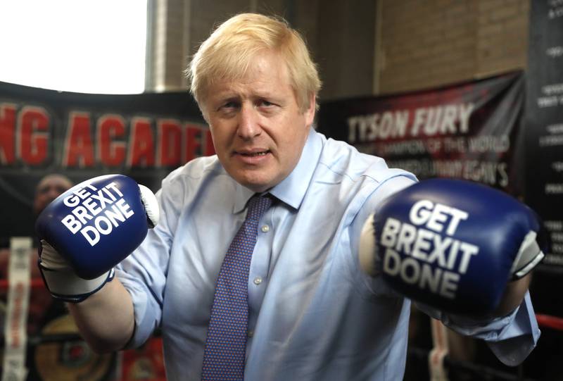 Mr Johnson poses for a photo wearing boxing gloves during a stop on his general election campaign trail in Manchester, in November 2019. Getty Images