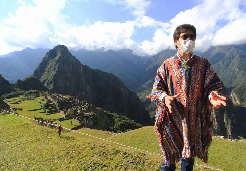 Jean Paul Benavente, Governor of Cusco, talks to experts and authorities assessing the new health and distancing protocols in order to reopen the Inca citadel of Machu Picchu (background) to the public on July 1 during a visit to the ruin grounds on June 12, 2020. AFP