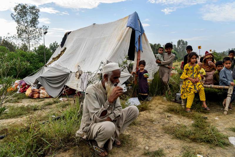 People take refuge by a highway after fleeing from their homes in Charsadda district, Khyber Pakhtunkhwa province. AFP
