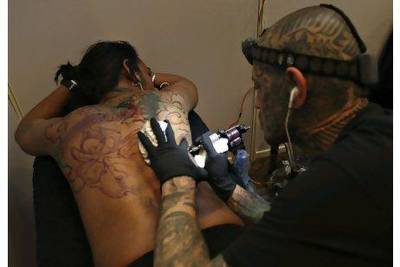 A tattoo artist inks a customer's back during the Nepal Tattoo Convention in Kathmandu last week. Some 57 tattoo artist from 10 countries participated.