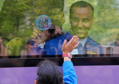 Hazza Al Mansouri waves to relatives from a bus prior to the launch of the Soyuz rocket at 5.56pm. Dmitri Lovetsky / AP Photo