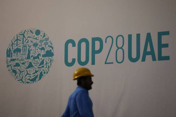 A worker passes an event sign ahead of the Cop28 climate conference at Expo City in Dubai, UAE. Bloomberg