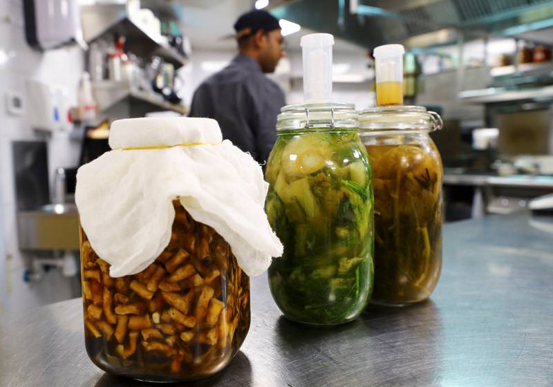 Large jars of fermented fruits and vegetables are lined up in the kitchen, where the chef uses his creations to add a twist to his dishes.

