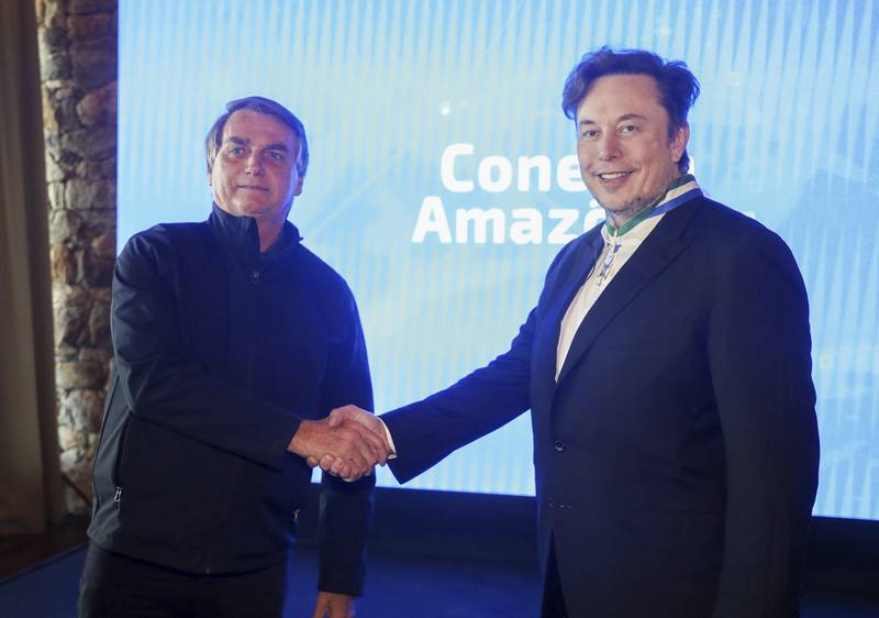 The entrepreneur shakes hands with Brazilian President Jair Bolsonaro in Porto Feliz, Brazil, in May. AP