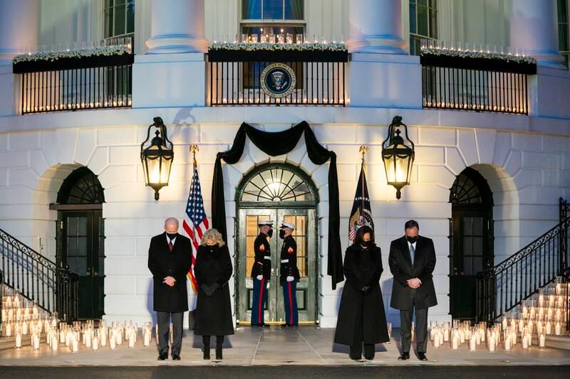 Mr Biden, left, Ms Biden, second left, Ms Harris, third left, and Second Gentleman Doug Emhoff hold a moment of silence outside the White House on February 22 for the 500,000 Americans who have died from Covid-19. EPA