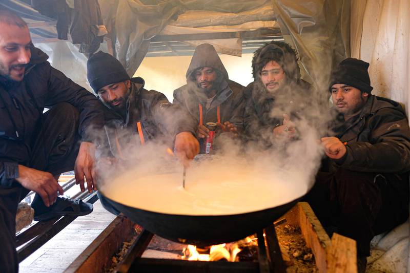 Migrants cook inside a makeshift shelter at the Lipa camp, outside Bihac, Bosnia. AP Photo