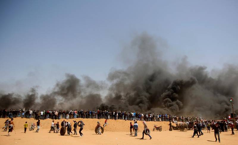 Palestinian protesters stand on sands hill. Adel Hana / AP Photo
