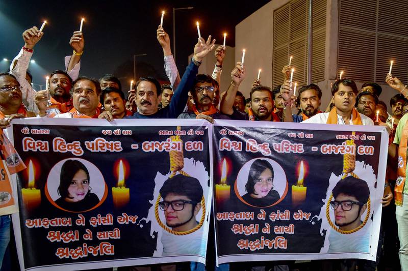 Supporters of Vishwa Hindu Parishad (VHP) and Bajrang Dal display banners with a portrait of Shraddha Walker, who was allegedly killed by her paramour in New Delhi, during a candlelight vigil held in Ahmedabad on November 17, 2022.  (AFP)