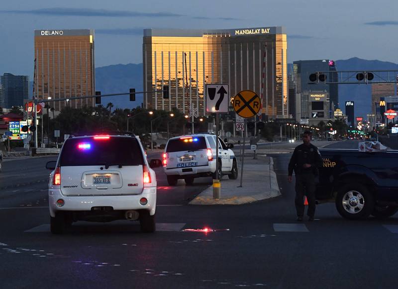 Police form a perimeter around the road leading to the Mandalay Hotel (background) after a gunman killed at least 50 people and wounded more than 400 others when he opened fire on a country music concert in Las Vegas, Nevada on October 2, 2017. Mark Ralston / AFP