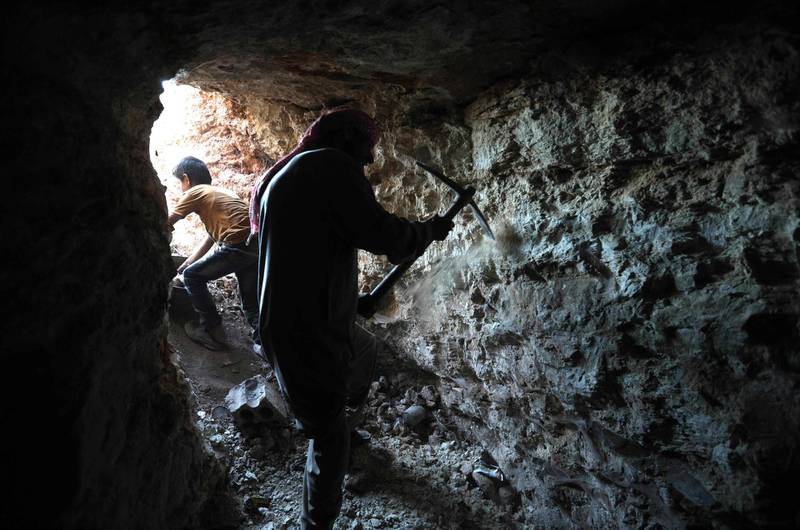 A man uses a pickaxe to dig a cave in the Syrian village of Kafr Ain in the southern countryside of the rebel-held Idlib province on September 15, 2018. Residents of Idlib province and surrounding areas have been bracing themselves for a Russian-backed government offensive on the country's largest remaining rebel-held zone. / AFP / OMAR HAJ KADOUR

