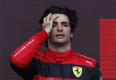 Ferrari's Carlos Sainz celebrates winning the race on the podium. Reuters