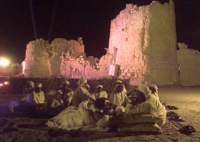 Arabs working at a desert party take a break in front of the ruins of an old fort on March 24, 2000. About 1,000 guests from around the world were treated to a lavish desert party under a starry sky in advance of the $6,000,000-prize Dubai World Cup horse racing event on March 25, 2000.