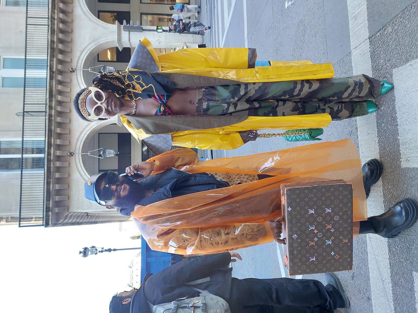 Ce couple a été aperçu en train de traverser la route devant le musée du Louvre.  Il porte un manteau propre et porte une valise, elle est en pantalon de combat et talons hauts bleus.  Sarah Maisey / Le National