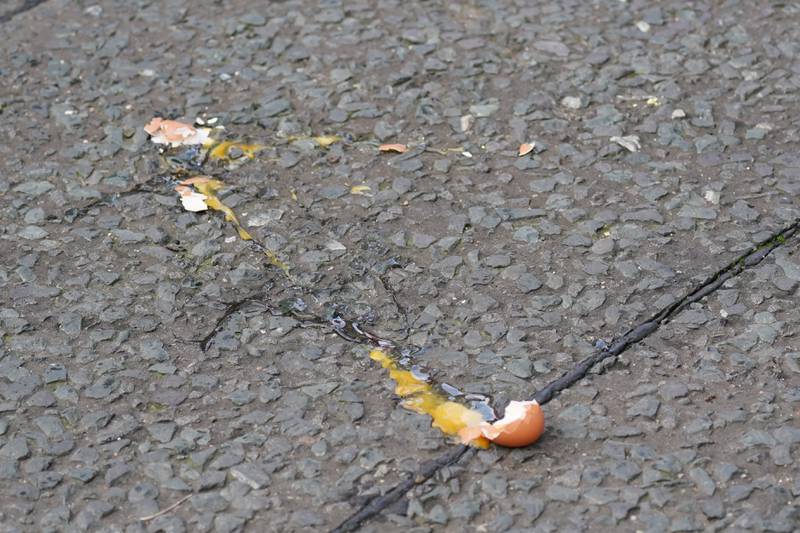A broken egg on the street after it was thrown at King Charles. PA