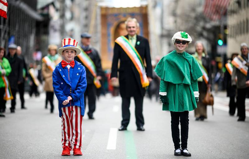 A boy dressed as 'Uncle Sam' and a girl dressed in all green make their way up 5th Avenue during the annual New York City St. Patrick's Day Parade on March 16, 2019. - The New York City St. Patrick's Day parade, dating back to 1762, is the world's largest St. Patrick's Day celebration. (Photo by Johannes EISELE / AFP)