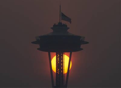 The Space Needle flies an American flag at half-mast in remembrance of the September 11 attacks as the sun sets through wildfire smoke in Seattle, Washington. AFP