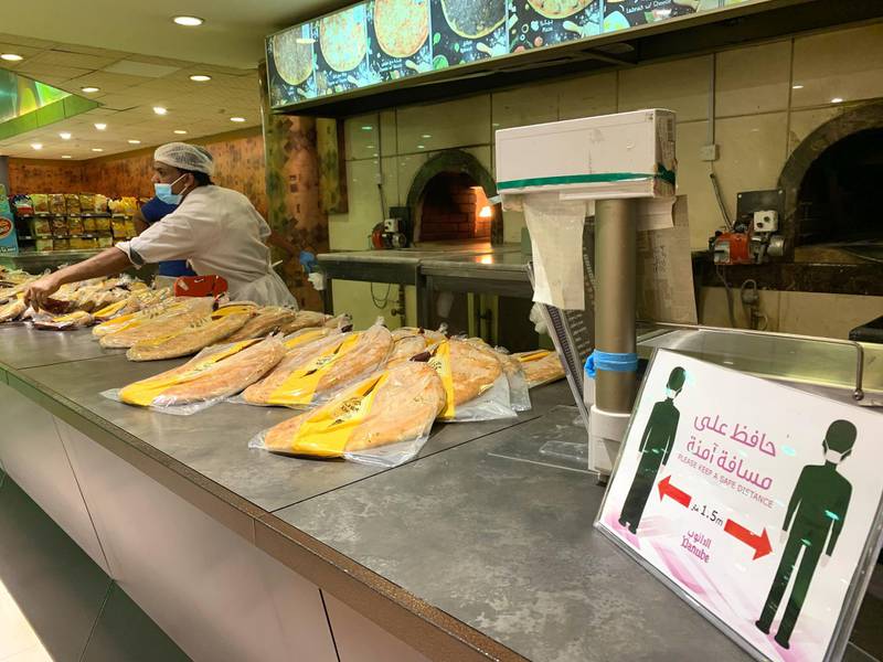 A sign reminds customers to stay at a safe distance from each other at a bakery in the nearly deserted Hayat mall in the Saudi capital Riyadh, after the lockdown measures due to the novel coronavirus were partially eased by the authorities.   AFP