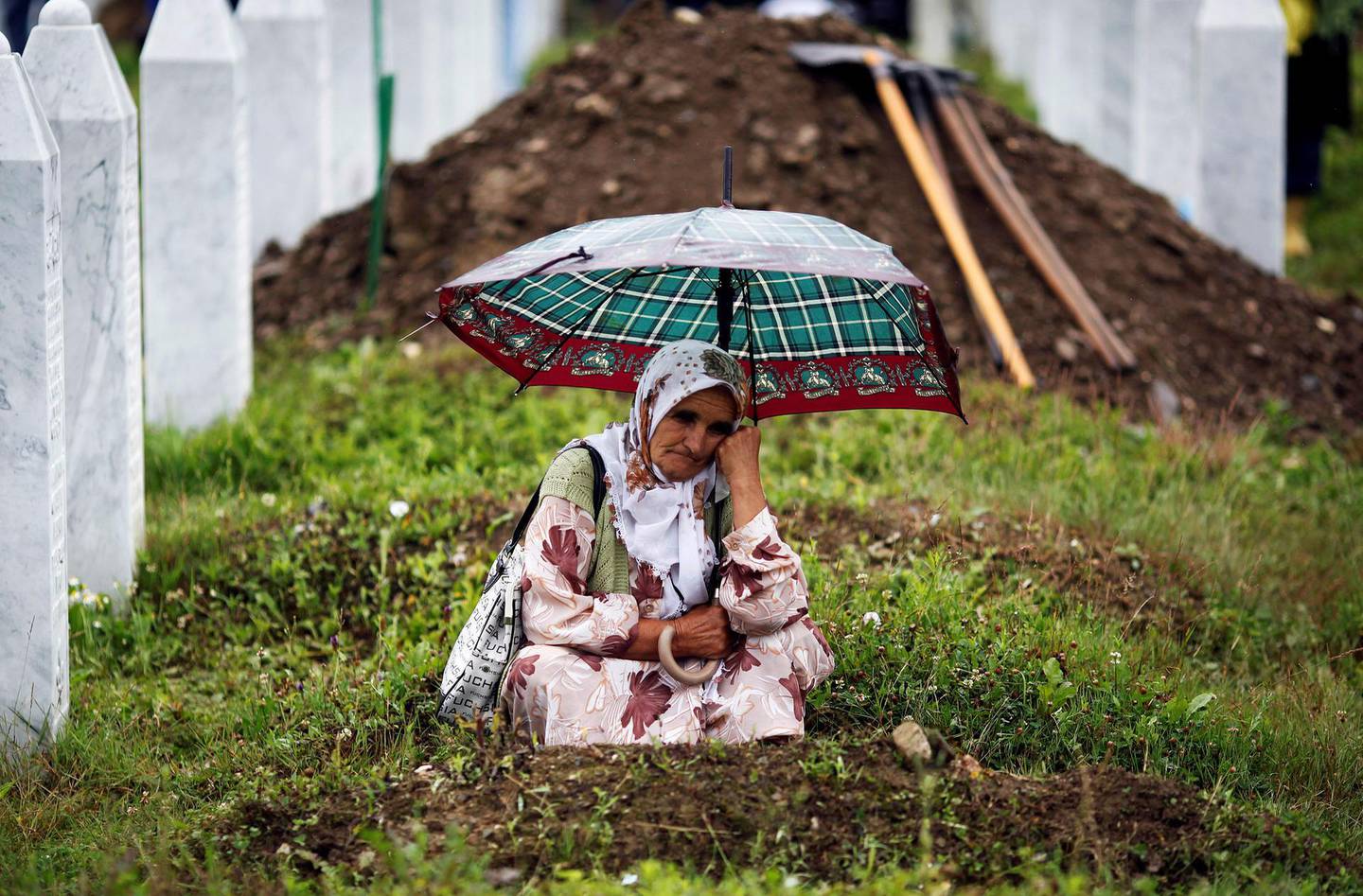 FILE PHOTO: A Muslim woman mourns by the grave of her relative during the funeral of 534 newly identified victims of the 1995 Srebrenica massacre in Potocari July 11, 2009. Bosnia will mark the 25th anniversary of the massacre of more than 8,000 Bosnian Muslim men and boys on July 11, 2020, with many relatives unable to attend due to the novel coronavirus pandemic.  REUTERS/Damir Sagolj/File Photo