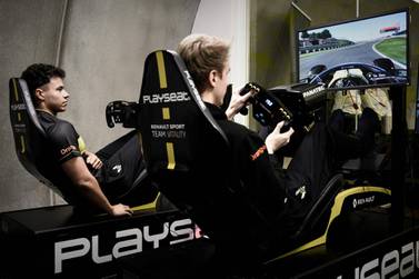 (FILES) In this file photo taken on November 25, 2019 members of the esport team Vitality, Simon Weigang (L) and Cedric Thome both of Germany demonstrate their skills on the official esport F1 video game, at the Formula One motor racing Renault F1 Team headquarters in Enstone. Motor sports, which made the bet a few years ago to invest in the esports, are paying dividends thanks to the multiple virtual races which allow them to continue to exist in the days of the coronavirus. / AFP / Philippe LOPEZ