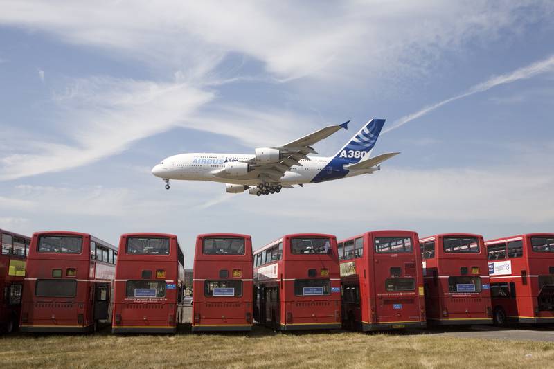 The new Airbus A380 double decker airliner comes in to land over a double decker busses in the 2006 Farnborough Airshow.