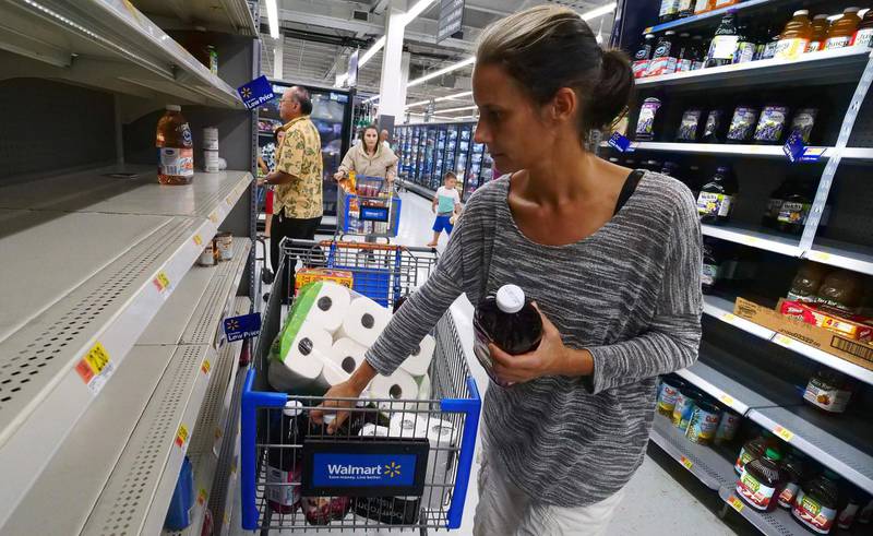 Erica McMillan stocks up with what's left on the shelves at Walmart in Oahu, Hawaii on   August 22, 2018, in preparation for the arrival of Hurricane Lane. - Residents of Hawaii on August 22 were bracing for a rare landfall by a powerful hurricane as they stocked up on water, food and emergency supplies. Hurricane Lane, which weakened slightly to a category 4 storm overnight, is packing 155-mile-per-hour winds and is expected to reach the archipelago's Big Island by nightfall. (Photo by Ronen ZILBERMAN / AFP)