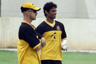 The Bangladesh cricketer Farhad Reza ,right, talks with coach James Siddons during a training session in Karachi.