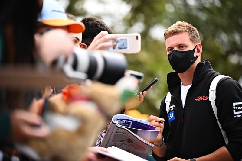 Haas driver Mick Schumacher arrives at the circuit and signs autographs for fans. Getty