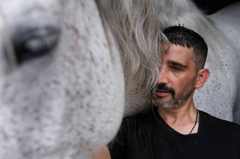 Turkey's first Paralympic rider, Tolga Dokuyucu, stands next to horse Balfi after training at the Equestrian Sports Club in Ankara. All photos: EPA