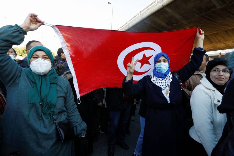 Protestors hold the Tunisian flag in Tunis. Reuters