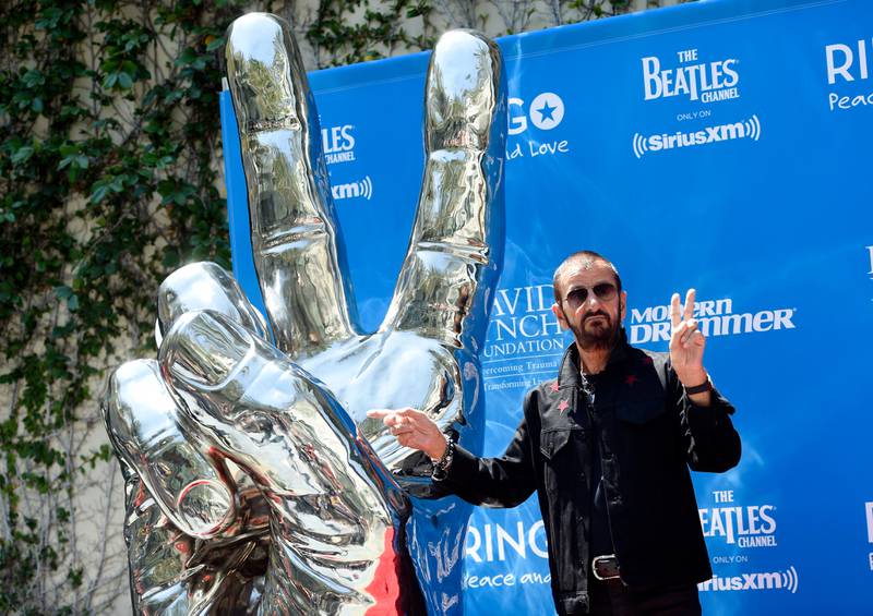 Ringo Starr mimics a peace sign statue during a 77th birthday celebration for the former Beatle at Capitol Records on Friday, July 7 in Los Angeles. Courtesy Chris Pizzello/Invision/AP