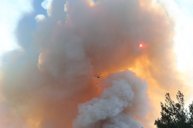 An emergency helicopter tackles a raging forest wildfire, which broke out in the Datca district of Mugla, Turkey. AFP