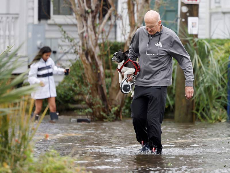 A man carries his pet dog on a flooded street in historic Charleston. Reuters