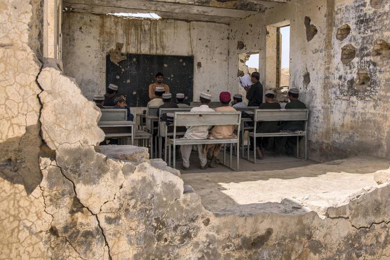 Students sit in their classroom at Assad Suri Primary School in Kandahar's Zhari District. Many of the buildings have been destroyed in airstrikes and by blasts, leaving classrooms exposed and bullet riddled. Part of the school continues to be occupied by the local police. 