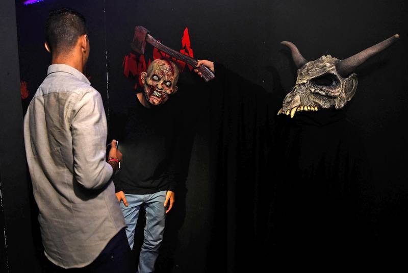 Saudi youths wearing masks play at "House of Terror", an entertainment activity now accessible to men and women during the the holy month of Ramadan in the Saudi Red Sea resort of Jeddah.  AFP