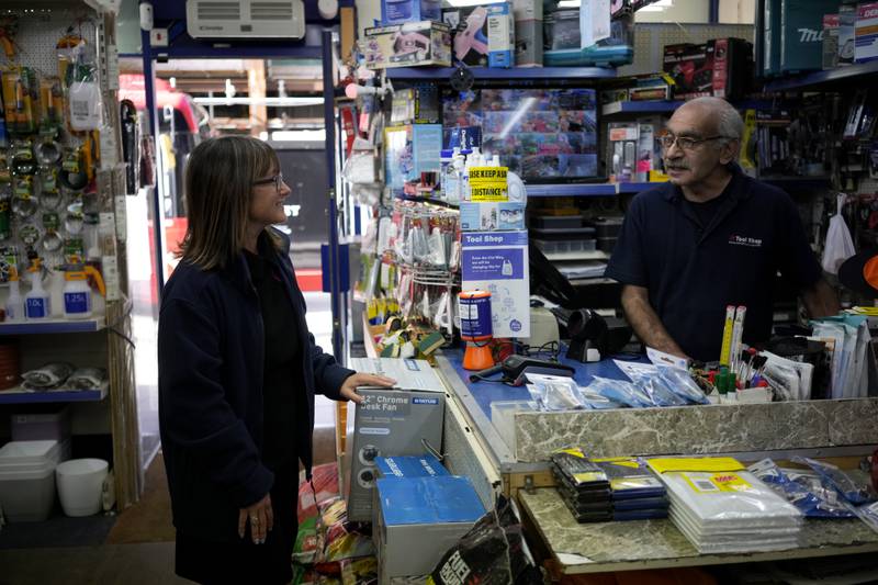 Sarah Edmiston, the company Administration Manager, chats with her colleague store employee Martin Matio at a branch of the Tool Shop hardware stores in the Bayswater area of central London. AP Photo