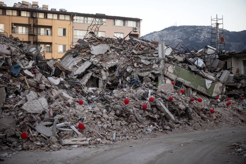Red balloons are attached to parts of a destroyed apartment building in Antakya, Turkey, following the deadly earthquake. Reuters