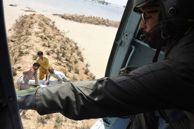 A Pakistan soldier drops tents and food aid from a helicopter in Jaffarabad District, Balochistan Province. AFP