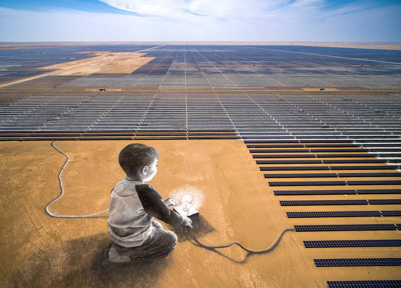 Swiss-French artist Saype has created a giant painting of a small child igniting a lightbulb next to the Ibri 2 solar power plant, in the desert of Oman. All photos: Reuters