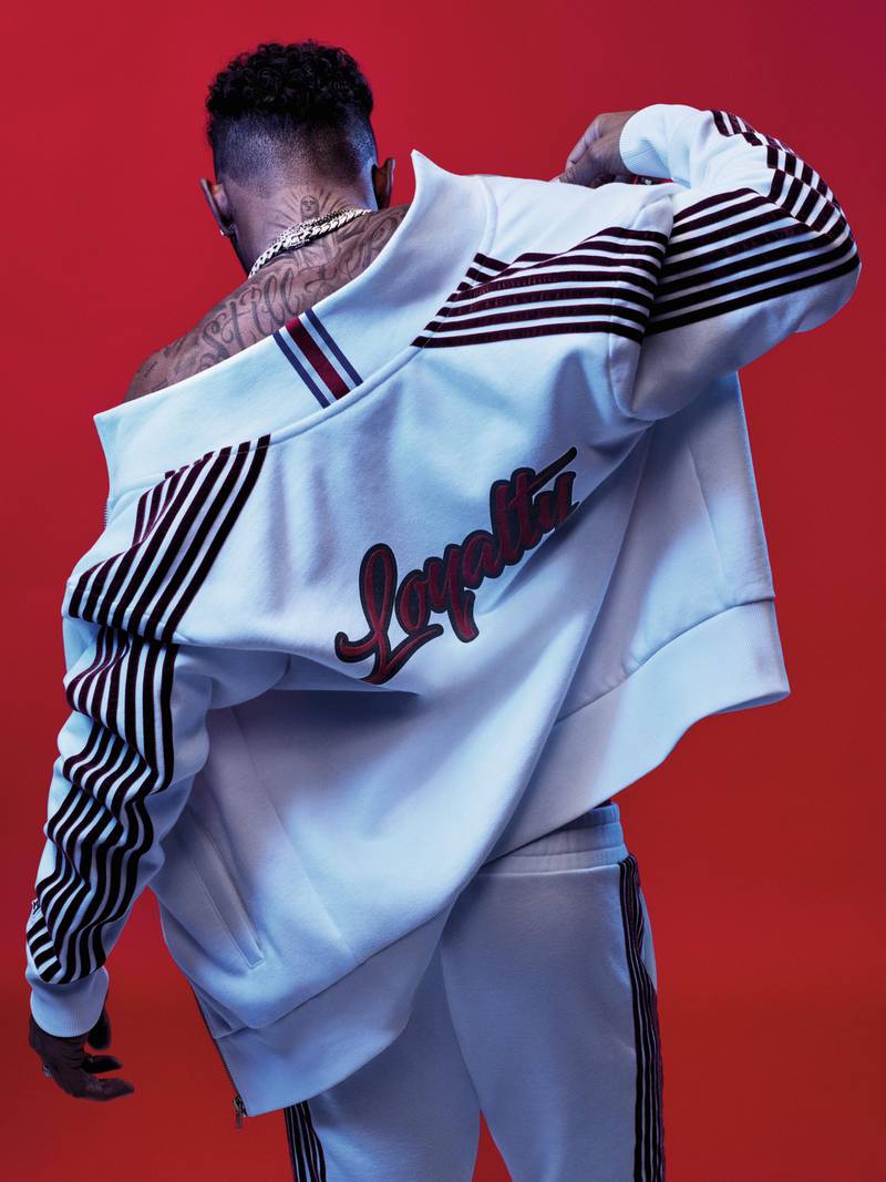 A white tracksuit with velvet stripes on the arm and leg seams nd the world loyalty, inspired by Lewis' own tattoo, on the back. Courtesy Tommy Hilfiger