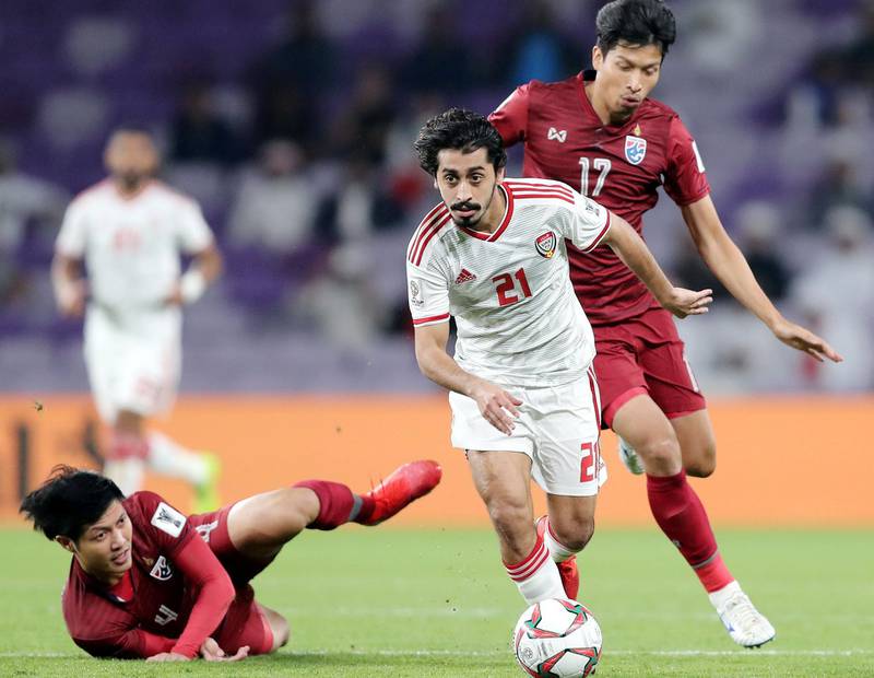 Al Ain, United Arab Emirates - January 14, 2019: Khalfan Mubarak of UAE and Tanaboon Kesarat of Thailand battle during the game between UAE and Thailand in the Asian Cup 2019. Monday, January 14th, 2019 at Hazza Bin Zayed Stadium, Al Ain. Chris Whiteoak/The National