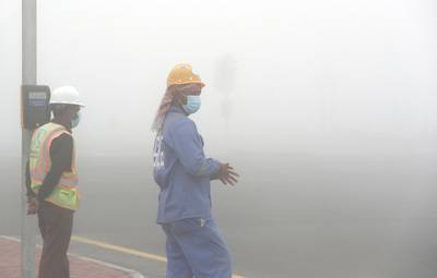 DUBAI, UNITED ARAB EMIRATES , April 08 – 2020 :- Workers during the early morning fog in Discovery Gardens area in Dubai. Dubai is conducting 24 hours sterilisation programme across all areas and communities in the Emirate and told residents to stay at home. UAE government told residents to wear face mask and gloves all the times outside the home whether they are showing symptoms of Covid-19 or not. (Pawan Singh/The National) For News/Online/Instagram/Standalone